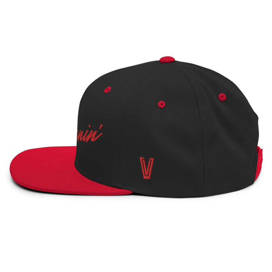 Left side profile of black snapback UNLV Runnin' Rebel basketball hat with red bill and vintage style Runnin' in red script